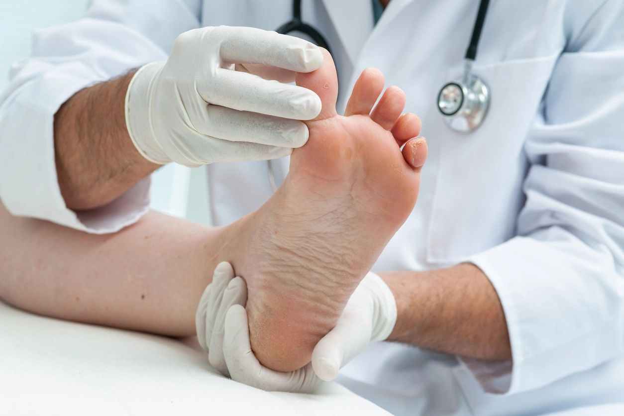 A doctor is examining the foot of a patient.