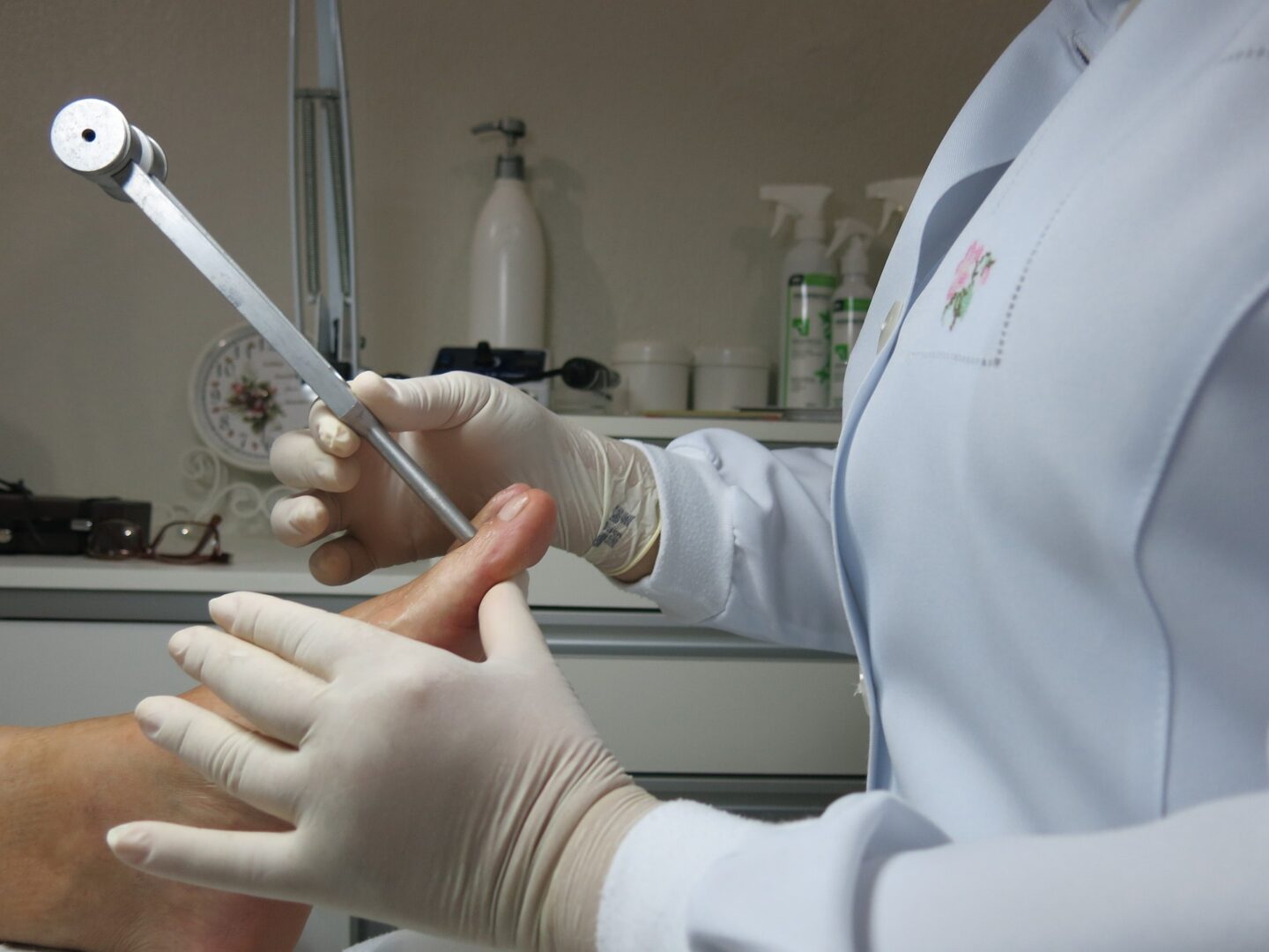 A person in white gloves holding a pair of scissors.